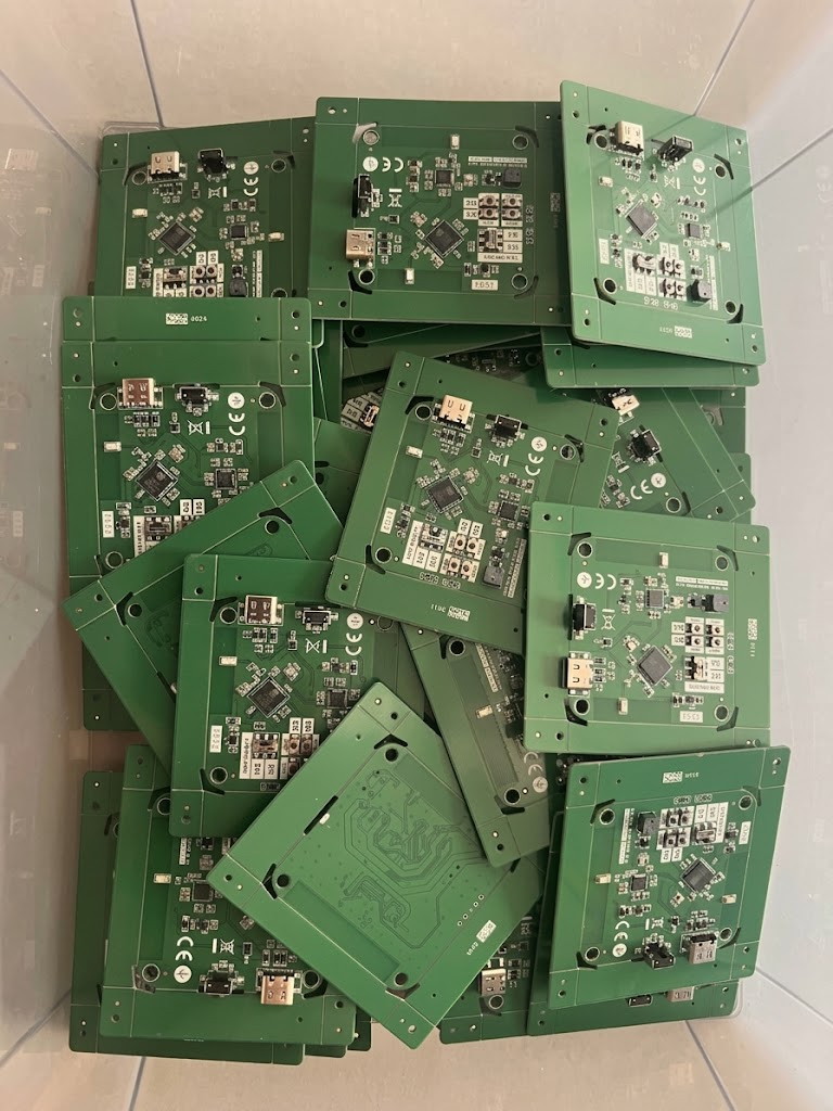 A tray of assembled Svitgrid ED-1 mainboards, each with a USB-C connector and the S3/H2 radio select header
